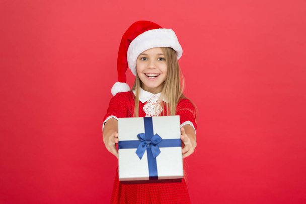Cheerful kid carnival costume red background. Surprise for her. Happy winter holidays. Small girl opening gift. New year. Santa claus gift. Little girl child received gift. Present xmas. Magic moment - 写真・画像