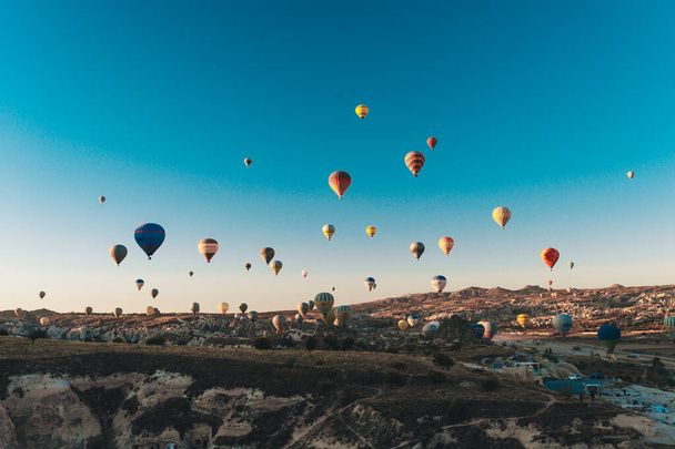 Hot air balloon flying over rock landscape in Cappadocia - Photo, image