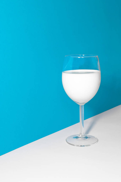 Glass of milk in blue and white background - Foto, afbeelding