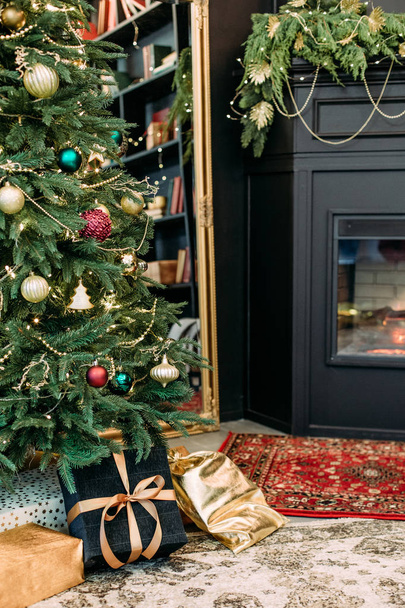 εσωτερικό εξαιρετικό μαύρο χρυσό τζάκι χριστουγεννιάτικο δέντρο - Φωτογραφία, εικόνα