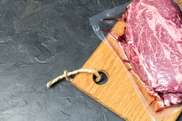 The marbled beef steak in a vacuum pack. - Fotó, kép