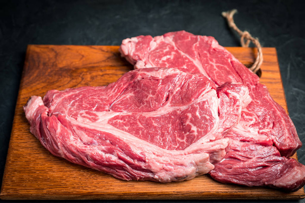 Raw marbled beef steak. Close-up photo on dark background. - Fotoğraf, Görsel