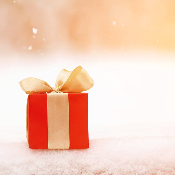 red winter Christmas gift box in snow background outdoors. - Foto, imagen