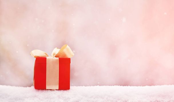 red winter Christmas gift box in snow background outdoors. - Φωτογραφία, εικόνα