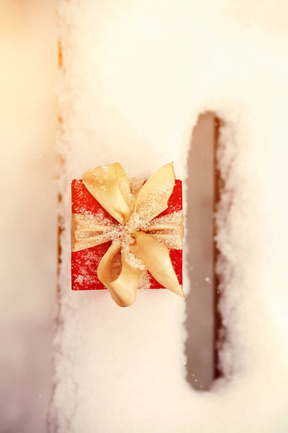 red winter Christmas gift box in snow background outdoors. - Fotografie, Obrázek