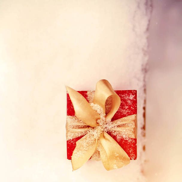 red winter Christmas gift box in snow background outdoors. - Photo, Image