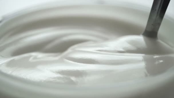 Makro - Videodreh, Zeitlupe des Mischens von Joghurt mit Löffel in der Tasse - Filmmaterial, Video