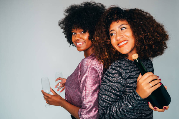 Portrait of a Black American African women with a glass of champagne. Celebrating and smiling. - 写真・画像