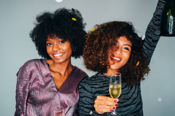 Portrait of Happy Two Young Beautiful African American friends toasting the champagne glasses with each other. Celebrating a Christmas holidays. - Foto, immagini