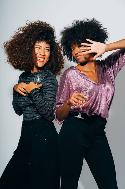 Due felici giovani amici afro-americani brindano ai bicchieri di champagne e ballano. Festeggiare una festa di Natale
. - Foto, immagini