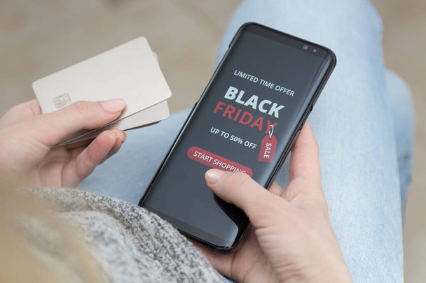 Девушка с мобильным телефоном в руках делает покупки онлайн в черную пятницу
 - Фото, изображение