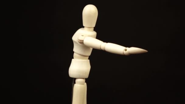 木製の人形は腕を前に出し黒い背景で360度回転させ - 映像、動画