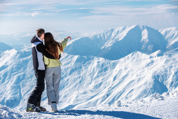 スキー場の雪上山脈を指差す恋人の姿ぐだり - 写真・画像
