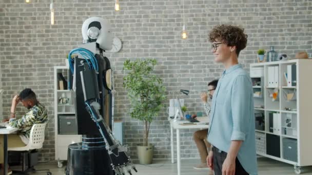 Cheerful girl shaking hand to intelligent droid smiling enjoying new technology - Záběry, video