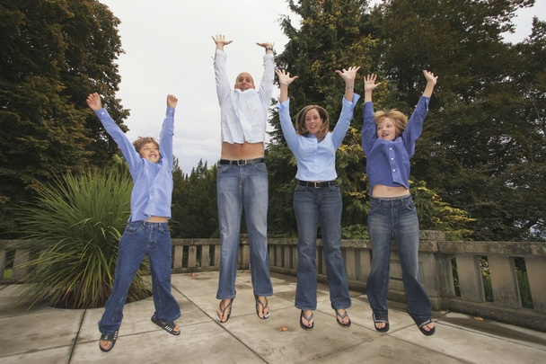 Family Jumping In The Air Together - Фото, изображение