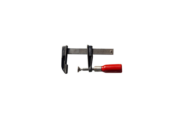 A small carpentry clamp with a red, wooden handle, isolated on a white background with a clipping path. - Photo, Image
