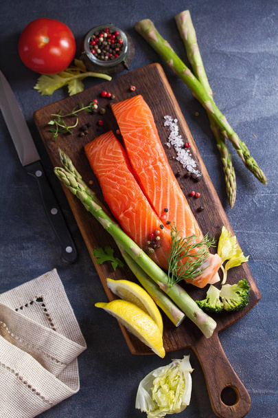 Fresh raw salmon fish fillet, asparagus, lemon, herbs and spices - Foto, afbeelding