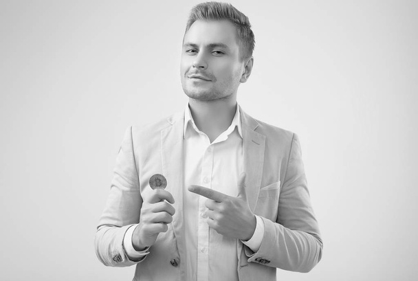 bel homme blond modèle dans un costume gris mode détient un Bitcoin
 - Photo, image