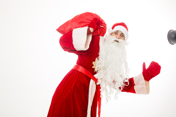 Mężczyzna w stroju Świętego Mikołaja trzyma czerwony worek z prezentami - Zdjęcie, obraz