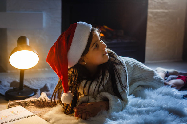süßes kleines Mädchen schreibt einen Brief an den Weihnachtsmann - Foto, Bild