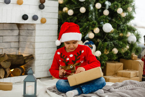Kleine jongen bij de kerstboom - Foto, afbeelding