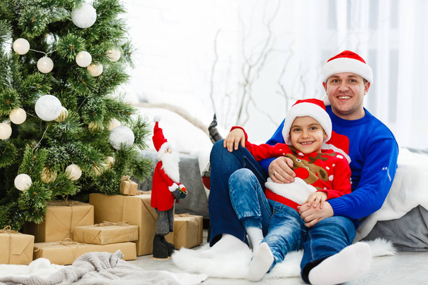 Smiling father and his son enjoying Christmas holidays at home - Foto, imagen