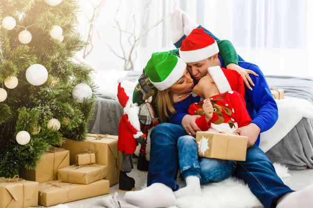 Чарівна сім'я сидить біля різдвяної ялинки
 - Фото, зображення