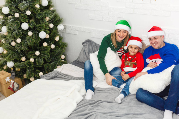 Madre, padre e hijo celebrando la Navidad juntos en casa
 - Foto, imagen