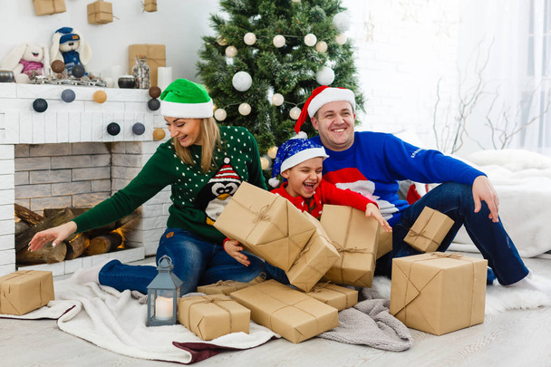 Mutter, Vater und Sohn feiern Weihnachten gemeinsam zu Hause - Foto, Bild