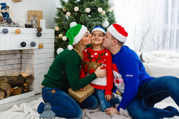 Äiti, isä ja poika viettävät joulua yhdessä kotona
 - Valokuva, kuva