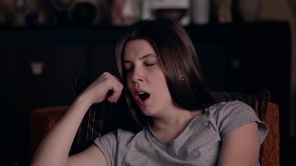 ヨーロッパ系の少女が疲れており、自宅のアームチェアであくびをしている。疲労の概念. - 映像、動画