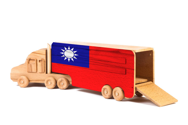 Nahaufnahme eines hölzernen Spielzeugwagens mit einer bemalten taiwan-Nationalflagge. das Konzept des Export-Imports, des Transports, der nationalen Lieferung von Waren  - Foto, Bild