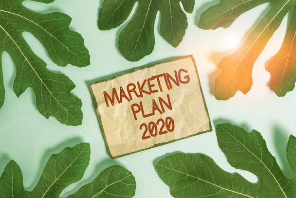 Pazarlama Planı 2020 'yi gösteren bir not yazılıyor. Marka satışlarını tanımlayan iş fotoğraflama takvimi gelecek yıl boş yumuşak pastel masa üzerinde etrafındaki not kağıtlarını bırakıyor. - Fotoğraf, Görsel