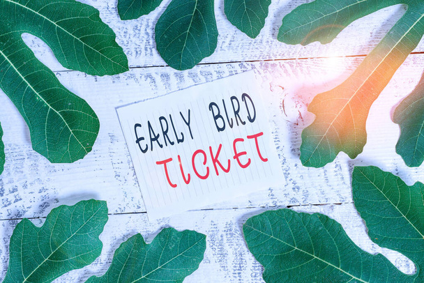 Εννοιολογική γραφή χεριών που δείχνει Early Bird Ticket. Business photo showcasing Αγοράζοντας ένα εισιτήριο πριν βγει προς πώληση σε κανονική τιμή Αφήνει γύρω σημειωματάριο πάνω από ένα κλασικό ξύλινο τραπέζι. - Φωτογραφία, εικόνα