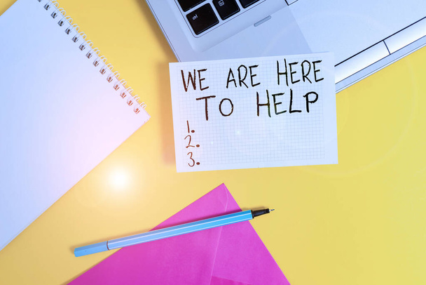 Conceptual hand writing showing We Are Here To Help. Business photo showcasing Someone who is always ready to Assist Support Give Laptop marker square sheet spiral notebook color background. - Photo, Image