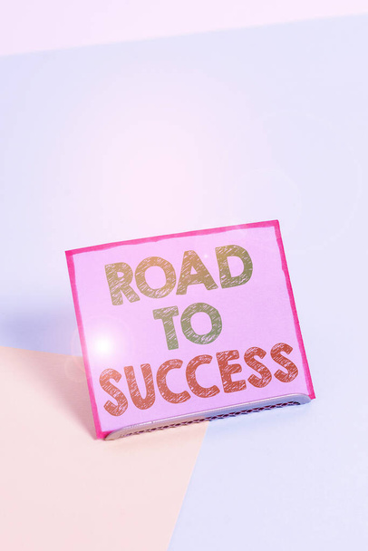 Текст слова Road To Success. Деловая концепция для изучения действительно трудно Улучшить себя, чтобы достичь мечты желания Буферная бумага, расположенная наклоненной над буферной проволокой на мягком пастельном многоцветном фоне
. - Фото, изображение