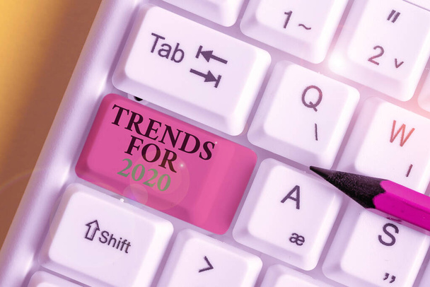 Konceptuální rukopis zobrazující trendy pro rok 2020. Obchodní fotografie zobrazující seznam věcí, které se staly populární velmi rychle v letošním roce Bílá PC klávesnice s poznámkovým papírem nad bílým pozadím. - Fotografie, Obrázek