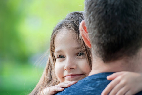 Portrait of cute little girl held in father's arms. Happy family - Fotografie, Obrázek