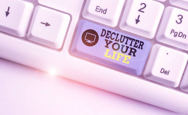 Handwriting text writing Declutter Your Life. Concept meaning To eliminate extraneous things or information in life White pc keyboard with empty note paper above white background key copy space. - Photo, Image