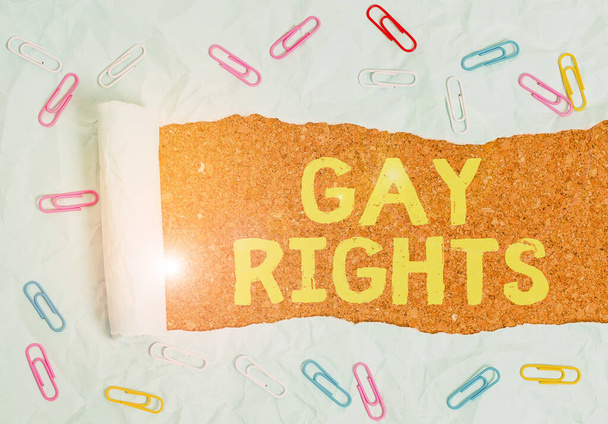 Text sign showing Gay Rights. Conceptual photo equal civil and social rights for homosexuals individuals Paper clip and torn cardboard placed above a wooden classic table backdrop. - Photo, Image
