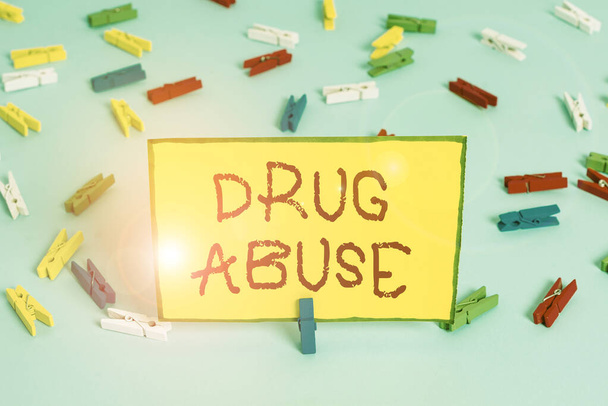 Word writing text Drug Abuse. Business concept for the habitual taking of addictive or illegal chemical substances Colored clothespin papers empty reminder blue floor background office pin. - Photo, Image