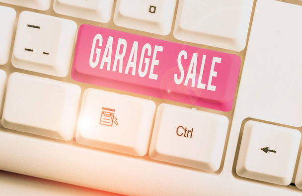 Writing note showing Garage Sale. Business photo showcasing sale of miscellaneous household goods often held in the garage White pc keyboard with note paper above the white background. - Photo, Image