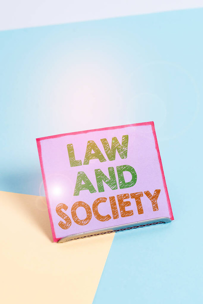 Word writing text Law And Society. Business concept for Address the mutual relationship between law and society Paper placed tilted above buffer wire on soft pastel multi colours backdrop. - Photo, Image