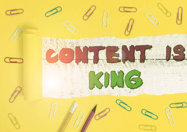 Word σύνταξη κειμένου Περιεχόμενο είναι ο βασιλιάς. Business concept for Content είναι η καρδιά των σημερινών στρατηγικών μάρκετινγκ Σταθερό και σκισμένο χαρτόνι τοποθετείται πάνω από ένα ξύλινο κλασικό πίνακα φόντο. - Φωτογραφία, εικόνα