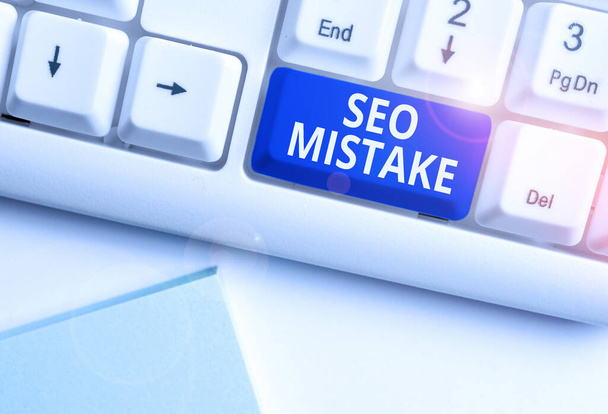 Conceptual hand writing showing Seo Mistake. Business photo text action or judgment that is misguided or wrong in search engine White pc keyboard with note paper above the white background. - Photo, Image