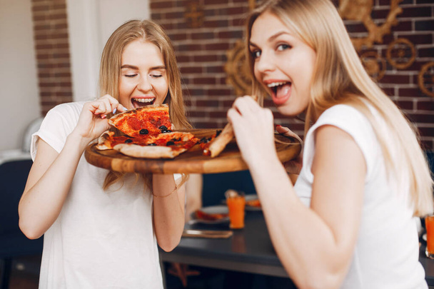 Cute friends in a cafe eatting a pizza - Photo, Image