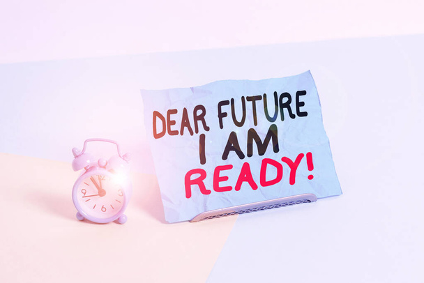 Writing note showing Dear Future I Am Ready. Business photo showcasing state action situation being fully prepared Alarm clock beside a Paper sheet placed on pastel backdrop. - Photo, Image