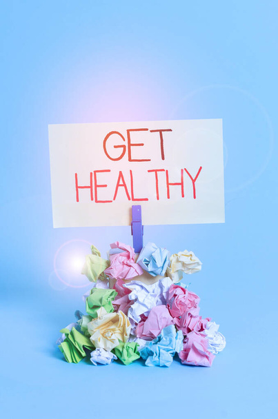 Píšu text Get Healthy. Obchodní koncept pro vlastnit nebo těší dobré zdraví nebo zdravou mentalitu Připomenutí hromada barevných zmačkaného papíru prádlopin připomenutí modré pozadí. - Fotografie, Obrázek