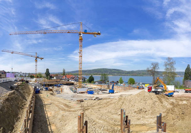 Big construction site with two cranes on a lake. Taken in Bodman at Lake Constance, Germany.  - 写真・画像