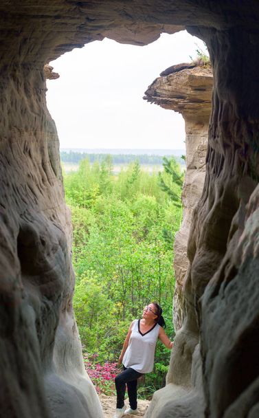 Yakut lány pózol a látnivalók-erozitsionnoy megkönnyebbülés és gomba a háttérben az északi erdő Yakutia. Fénykép a barlangból.. - Fotó, kép